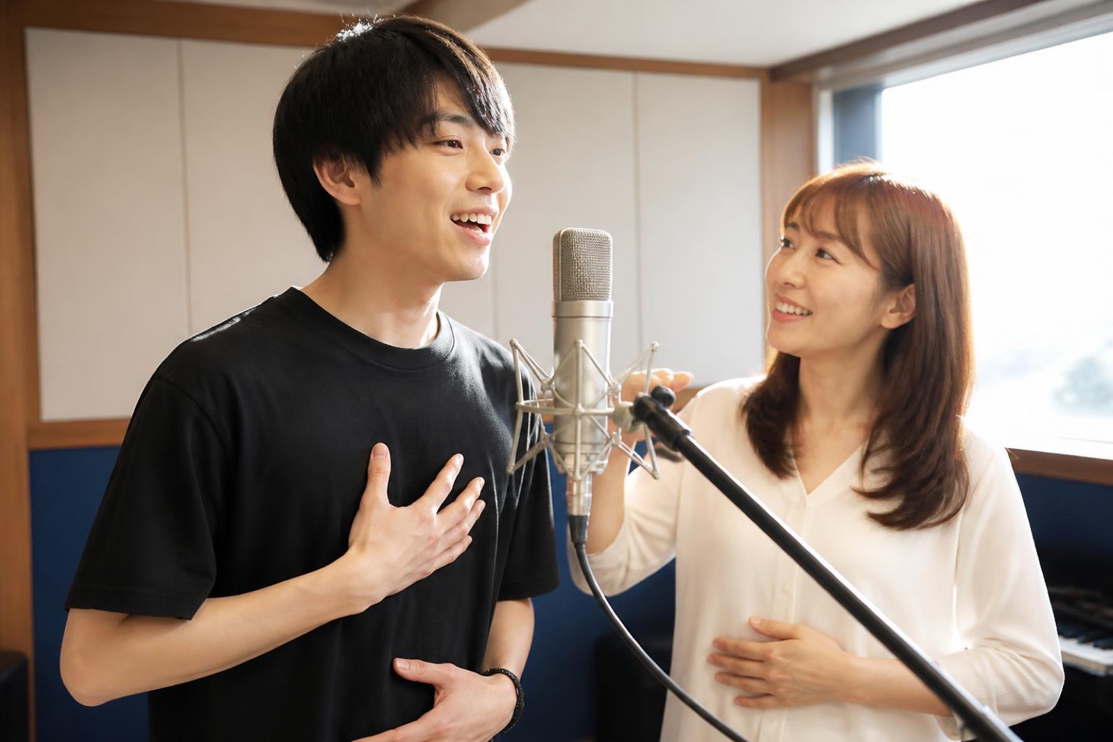 マイクの前で発声する人と講師