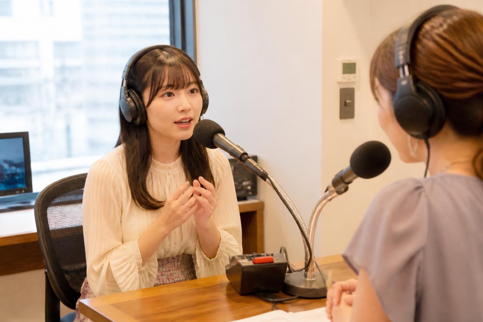 ラジオのスタジオでマイクに向かって話す女性